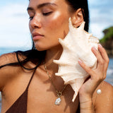 Isaro pearl necklace layered beneath a deeper piece