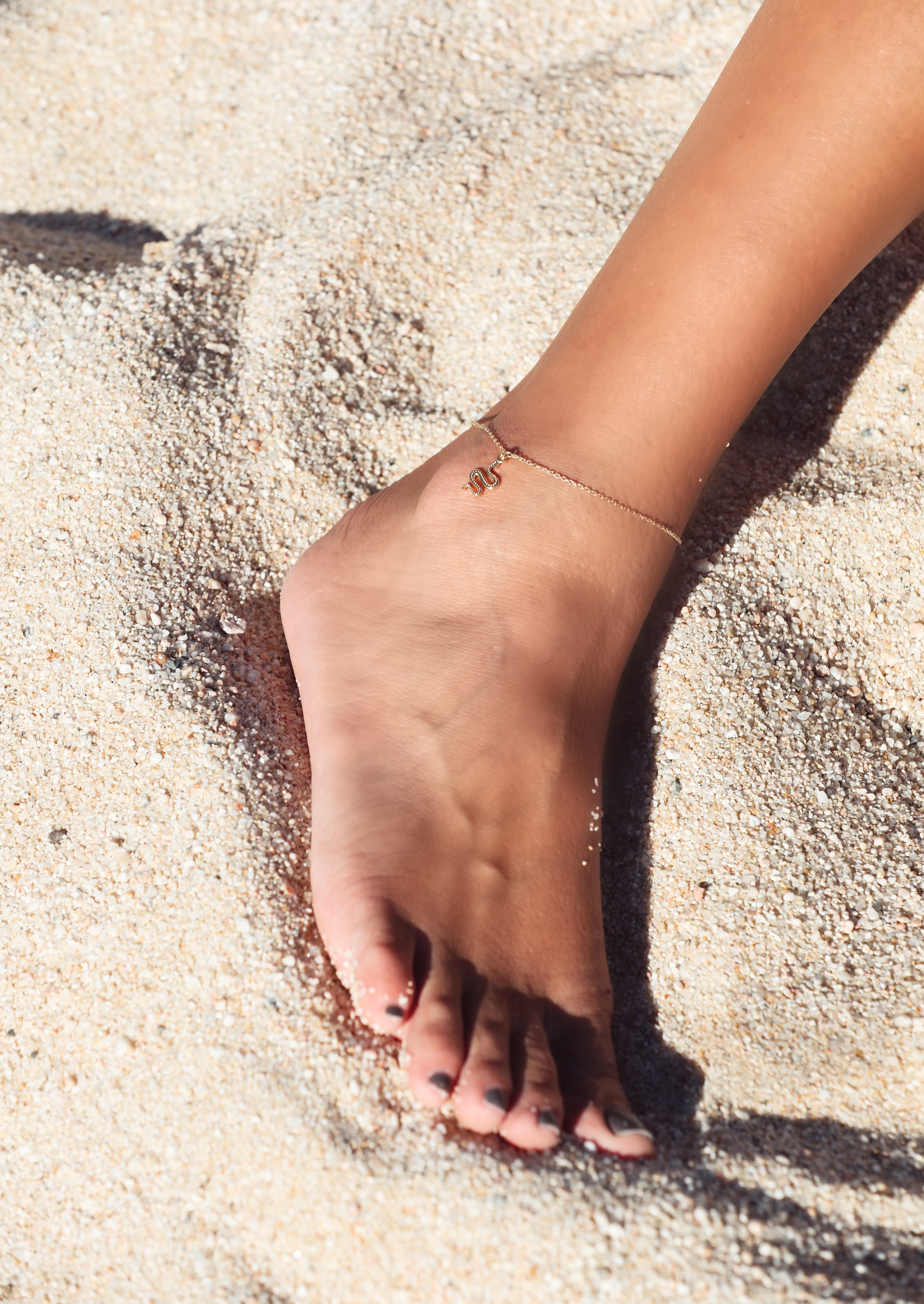 Ular serpent anklet in sterling silver, resting on the ankle