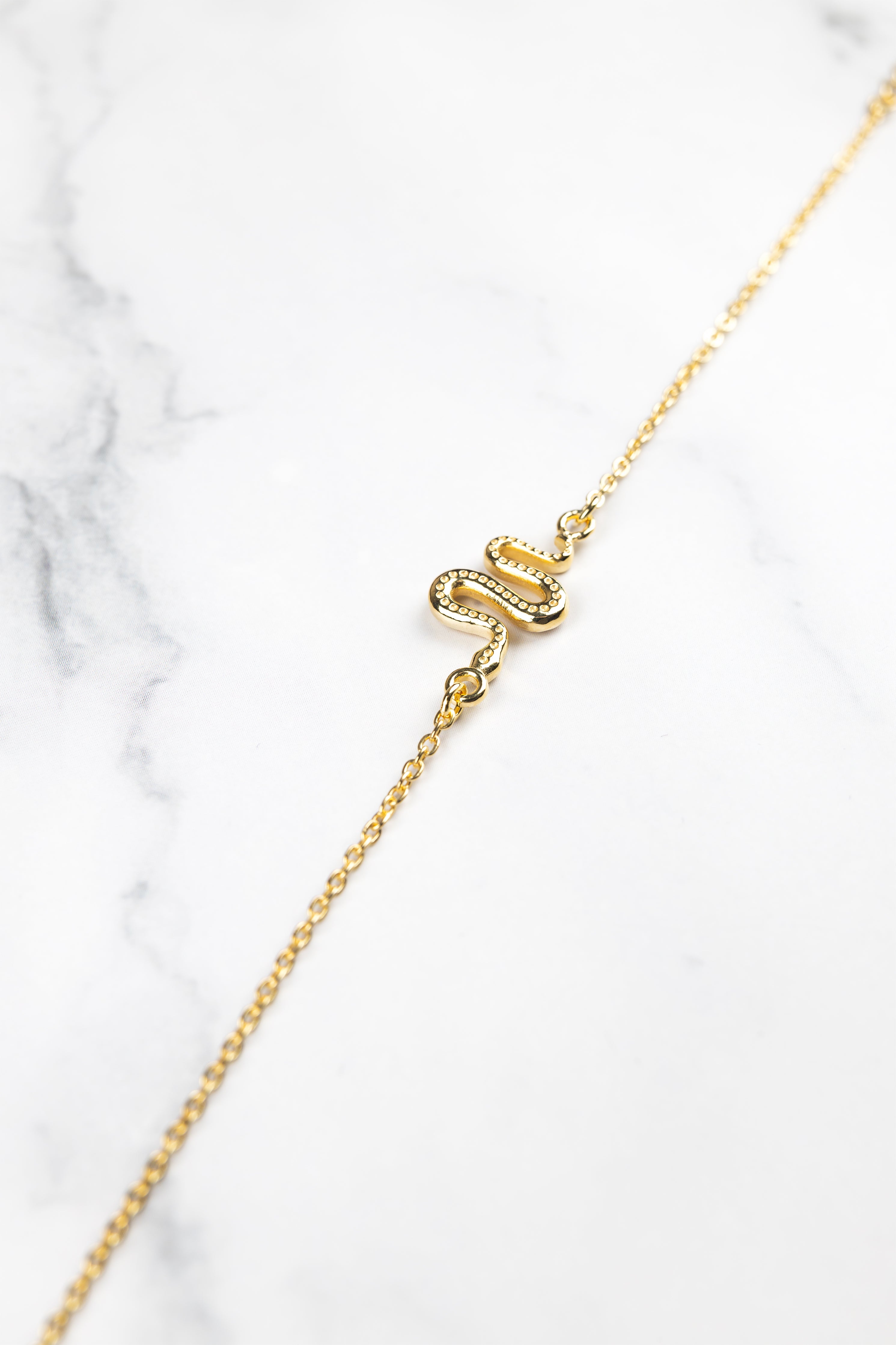 Ular serpent bracelet layered with heavier bracelets