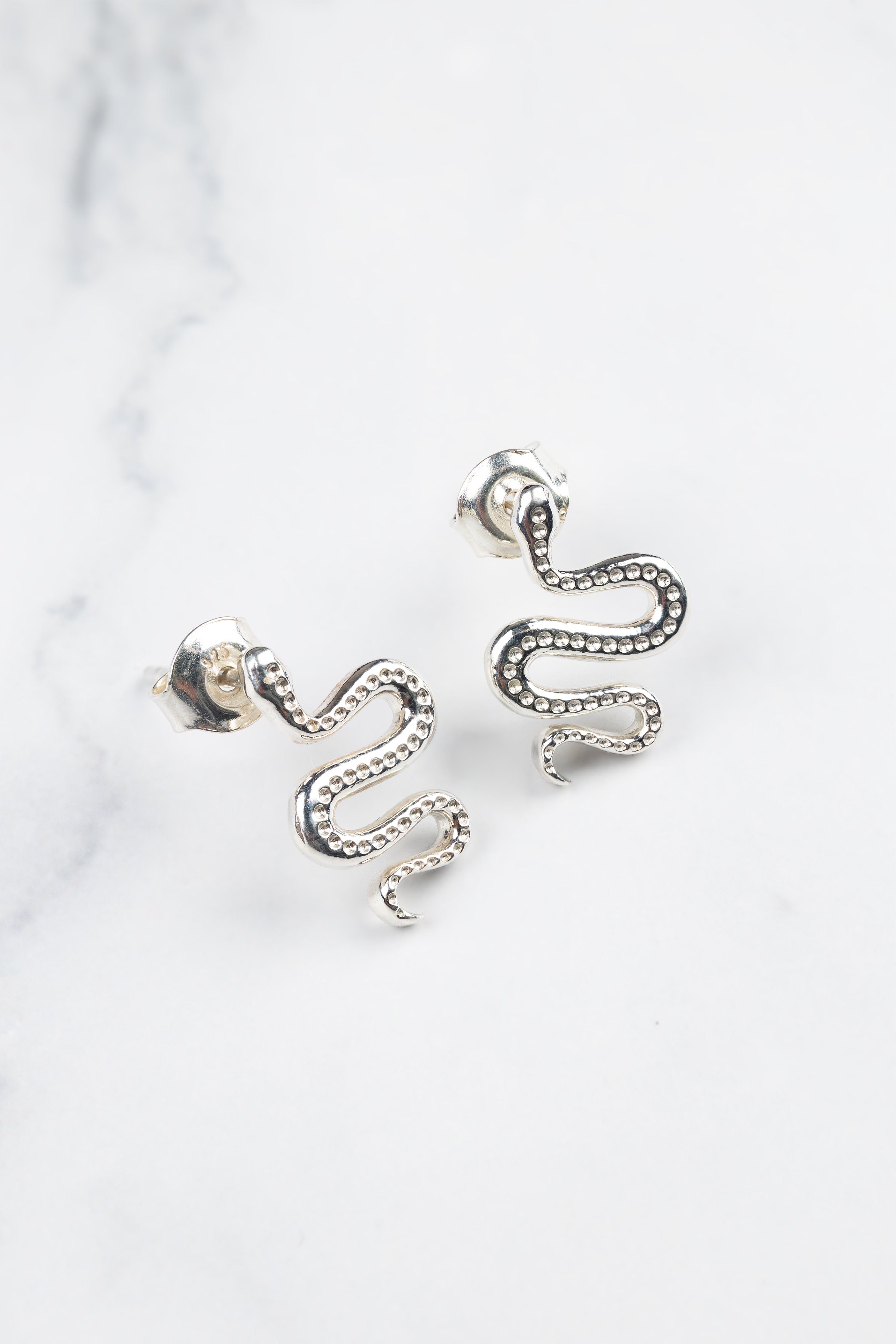 Ular serpent earrings, close-up of the curved silhouette