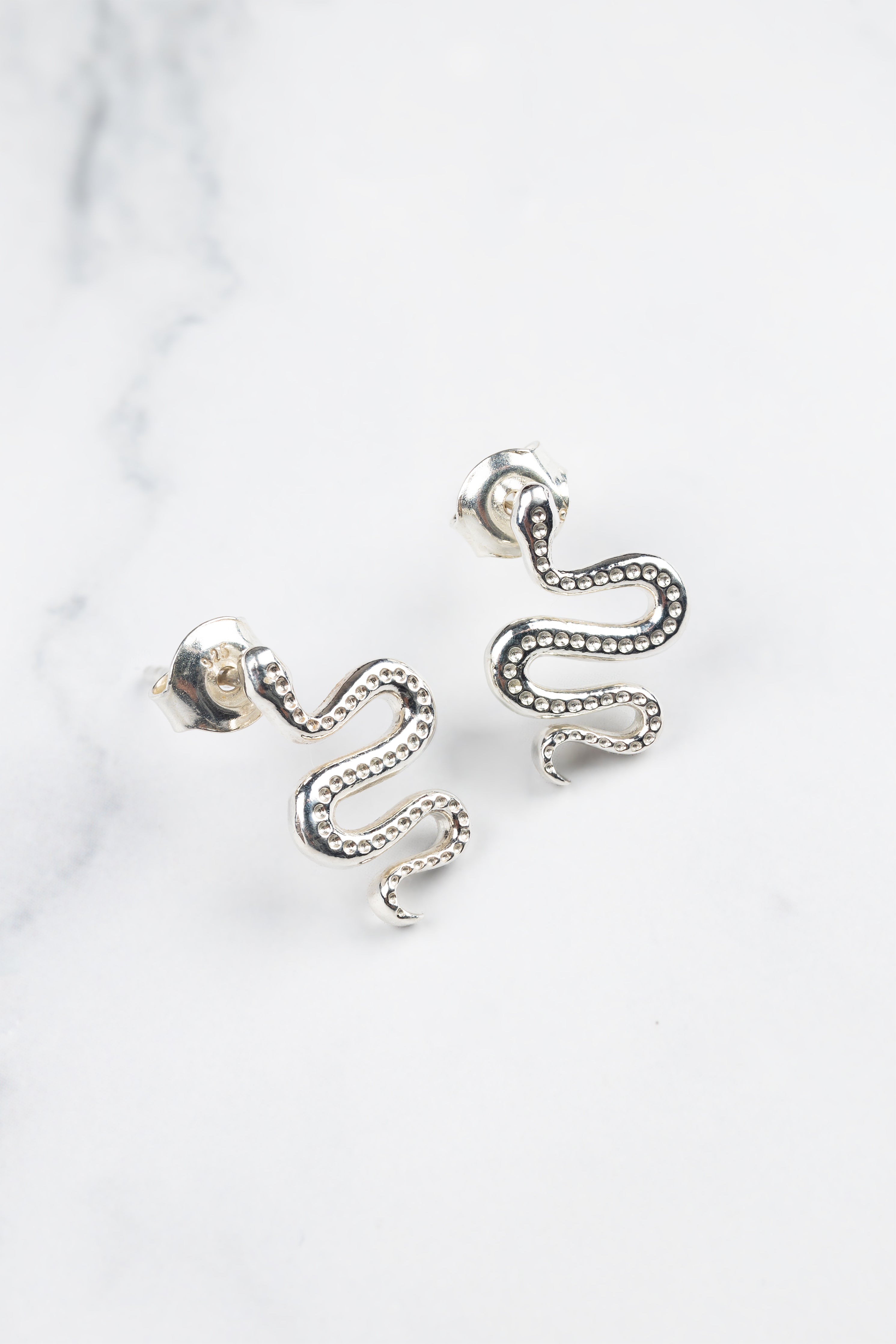 Ular serpent earrings, close-up of the curved silhouette