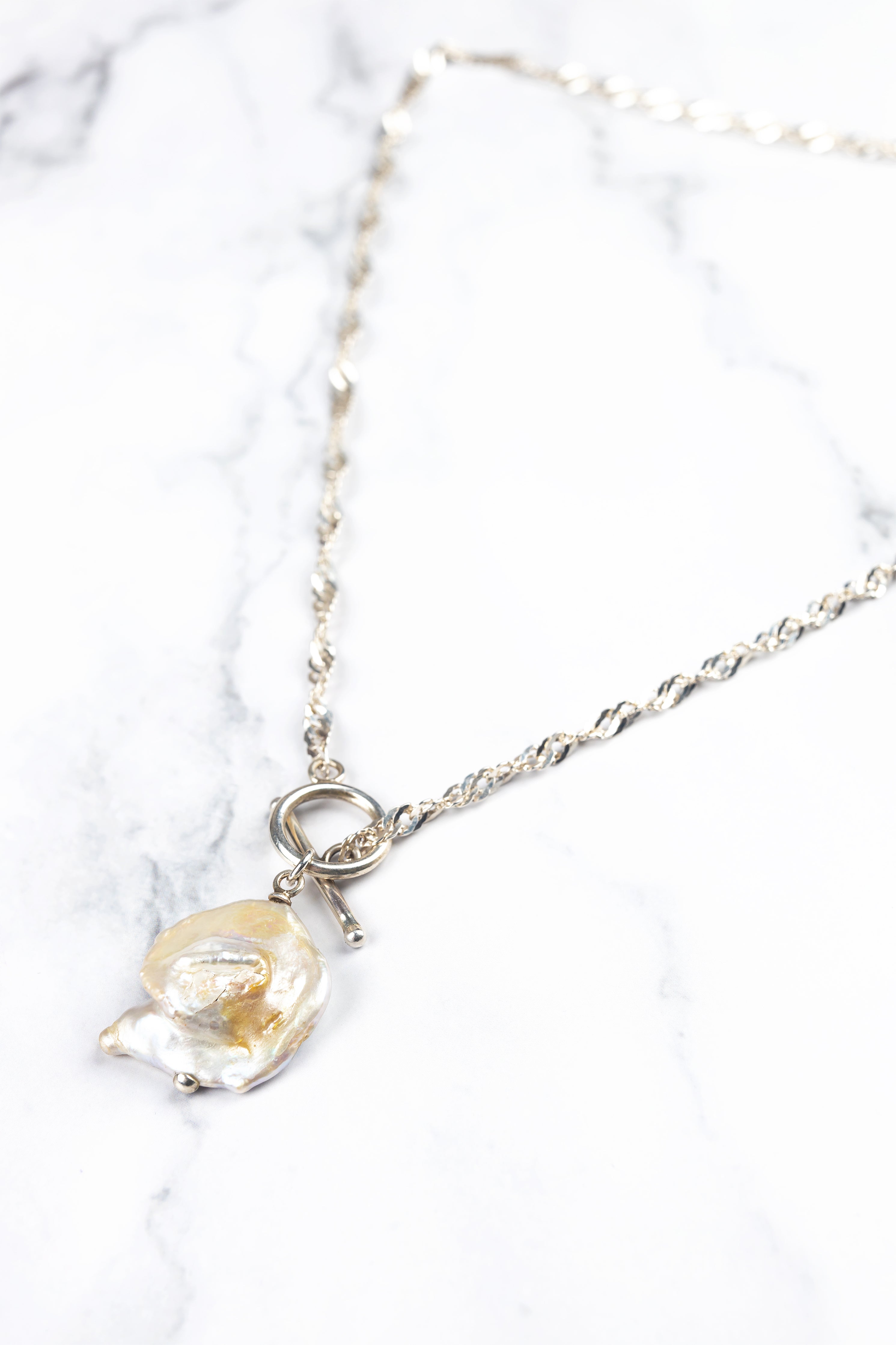Isaro pearl necklace, flat lay product photo