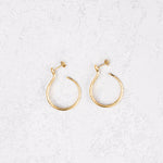 Sarpe serpent hoop earrings worn on bare skin, front view